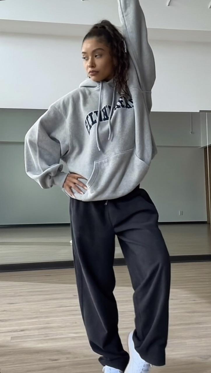 Original viral dance reel: a dancer in a grey hoodie strikes a pose in a studio
